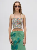 Top corto negro con textura fruncida, tirantes finos con lazos ajustables y corte crop.