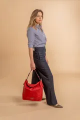 Cartera bandolera color marrón claro, de símil cuero, con dos divisiones internas, asa corta fija y correa larga regulable.