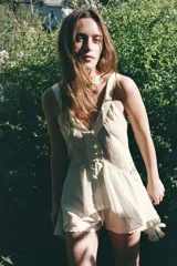 Top fluido color verde agua, de escote pico y tirantes anchos. Detalle de acabados satinados a contraste y bajo asimétrico con volados.