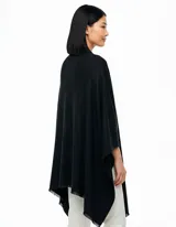 Ruana de tejido soft color beige, con cuello en V y un lazo o pasador frontal para ajustar. El ruedo tiene terminación desflecada.