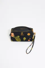 Neceser Bimba y Lola de nylon negro con estampado de cactus y flores naranjas. Tiene asa extraíble, piezas de piel, logo metálico, bolsillo interior y cierre con cremallera dorada.