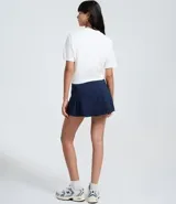 Remera blanca de manga corta, corte holgado, con un estampado central de personajes de Disney (Mickey, Pluto, Daisy, Donald y otros) y el texto "Mickey & Friends".