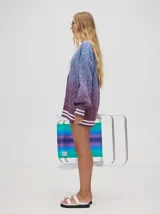 Cardigan tejido de punto con patrón de rombos en degradé de grises y blanco. Tiene corte oversize, mangas largas y cierre frontal con botones.