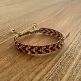 Pulsera tejida con cuentas Miyuki en tonos rojo oscuro y champagne, ajustable con cordón.