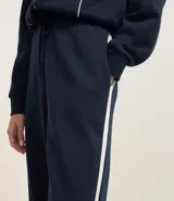 Pantalón de corte recto color marrón con raya lateral blanca y lazo en la cintura.
