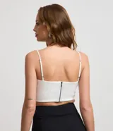 Top cropped blanco de bengalina con breteles finos ajustables y cierre trasero.