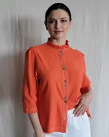 Camisa color beige claro con cuello con volados y mangas 3/4 abullonadas.