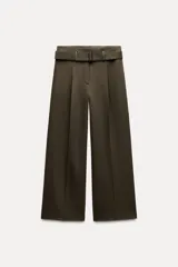 Pantalón de tiro medio color verde oliva, con cintura con trabillas, bolsillos laterales ocultos, cinturón ajustable con hebilla metálica, pinzas delanteras y cierre frontal con cremallera, botón y gancho metálico.