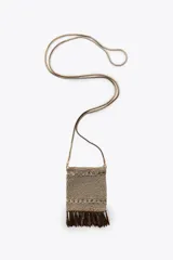 Bolso mini tipo saco confeccionado con hilo metalizado color dorado en forma de malla. Detalle de flecos metálicos labrados. Asa tipo cordón metálica.