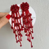Aros colgantes rojos con flores y cuentas.