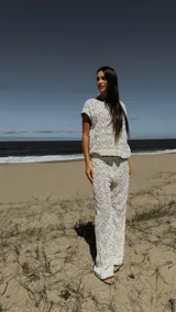 Pantalón blanco de broderie con tiro medio, cintura elástica, short de forro y pespunte negro en la terminación.