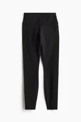 Calzas deportivas negras de tiro alto con bolsillos laterales, confeccionadas en tejido funcional DryMove™ que absorbe la humedad.