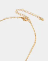 Collar corto dorado con cadena de eslabones y dijes de strass multicolor.