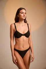 Conjunto de bikini negro con textura arrugada, compuesto por corpiño con aro y breteles anchos, y bombacha tipo colaless.