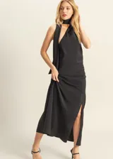 Vestido largo negro de satén con escote halter y abertura lateral en la falda. Incluye pañuelo al cuello.
