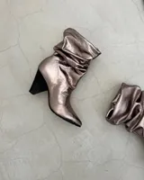 Botines dorados de cuero vacuno con punta fina y tacón aguja.