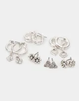 Set de seis pares de aros plateados con diferentes diseños: dos pares de argollas pequeñas lisas, dos pares de argollas con dijes colgantes (cruz y corazón) y dos pares de aros tipo botón (flor y triángulo).
