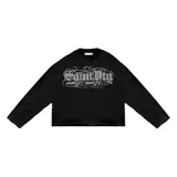 Remera negra oversize de manga larga, confeccionada en jersey de algodón grueso. Presenta cuello ancho y estampado frontal con el logo de la colaboración LUCCABOSSIO x Saint.
