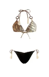 Bikini de dos piezas con estampado de hojas en tonos beige y marrón. El corpiño es de triángulo con tirantes que se atan al cuello y a la espalda, con detalle de argollas de madera en los tirantes y borlas en los extremos. La bombacha es reversible y se ata a los costados con tirantes con borlas.