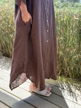 Vestido camisero amplio y largo de lino color azul, con botones de nácar, cuello camisero y bolsillos laterales.