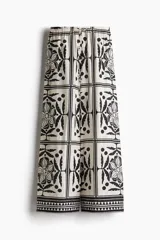 Pantalón de tiro alto con elástico revestido y cordón para ajustar fino en la cintura. Piernas amplias de corte holgado con estampado de flores y figuras geométricas en blanco y negro.