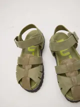 Sandalias romanas de cuero color tostado, con suela de goma y hebilla metálica lateral.