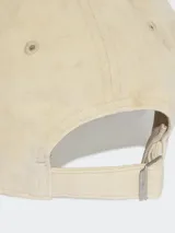 Gorra de béisbol color beige con logo Adidas bordado en gris en el frente.