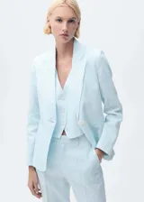 Chaqueta de lino color celeste con cuello de pico y solapas con muesca, cierre frontal con botón, manga larga con puños abotonados, diseño recto, dos bolsillos de ribete en la parte delantera y abertura posterior en el bajo.