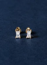 Par de aros pequeños de plata 925 con baño de oro 18k, con circonita rectangular transparente engarzada. Cierre a presión.