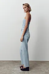 Pantalón de jean celeste de corte recto y largo, con tiro medio y cinco bolsillos.