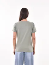 Remera negra de algodón con estampado frontal de la palabra "MERCI" en letras delineadas con colores del arcoíris.