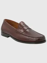 Mocasín de cuero color marrón de diseño clásico, con costuras decorativas y suela rígida.