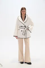 Chaqueta marrón con textura, doble botonadura, cuello en V, cinturón y capucha.