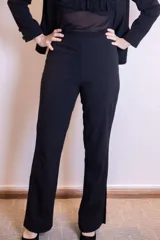 Pantalón negro de corte recto con finas rayas verticales.