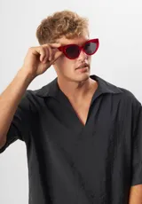 Gafas de sol con forma de ojo de gato, montura de acetato biodegradable color verde y lentes de PMMA reciclado color negro.