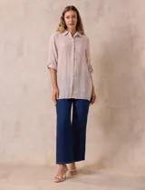 Camisa color beige claro, de corte recto y mangas 3/4 con botón para sujetar.