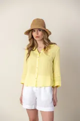 Camisa blanca de lino con cuello clásico, abotonada al frente y mangas 3/4 con puños.
