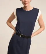 Vestido midi azul marino de algodón, con cuello redondo, sin mangas y detalle de sisa contrastante en color blanco. Incluye cinturón negro con hebilla metálica.