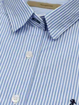 Camisa entallada de manga larga color rosa claro, con cuello clásico y cierre frontal con botones.