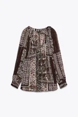 Blusa estampada con motivos paisley en tonos marrones, beige y verde, con escote en pico con volantes y abalorios, y mangas largas. Tejido con hilo metalizado.