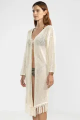 Cárdigan largo de punto abierto color crema con flecos en el ruedo y lazo de ajuste en el escote.