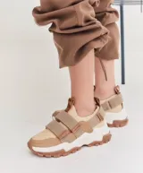 Zapatillas deportivas beige con detalles en marrón y suela gruesa blanca y marrón.