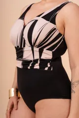 Malla entera con estampado abstracto en tonos blanco y negro, drapeada en el abdomen. Con buen sostén y cobertura de busto, y bolsillo interno para colocar copa removible o prótesis externa. Confeccionada con tela que contiene fibra LYCRA® XTRA LIFE™.