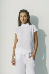 Blusa negra de lino con cuello alto y mangas cortas con detalle de calado en los hombros.