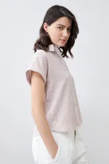 Camisa de manga corta con rayas verticales color beige y blanco.