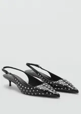Zapato destalonado negro con tachas plateadas, punta fina, tacón kitten y tira trasera ajustable.
