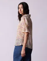 Blusa de gasa estampada marca Alex & Lili. Tiene cuello a la base con solapa y escote en V, mangas cortas con punto smock y terminación amplia. Delantera, solapa y mangas con aplique en crochet.