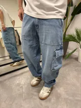 Pantalón de jean celeste, corte ancho, estilo cargo con bolsillos laterales.