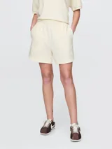 Short deportivo color crema, con cintura elástica ajustable con cordón y logo bordado en la pierna izquierda.