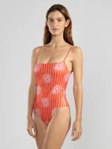 Traje de baño enterizo rojo con estampado de flores rosas, escote recto, breteles finos y espalda con lazo ajustable.